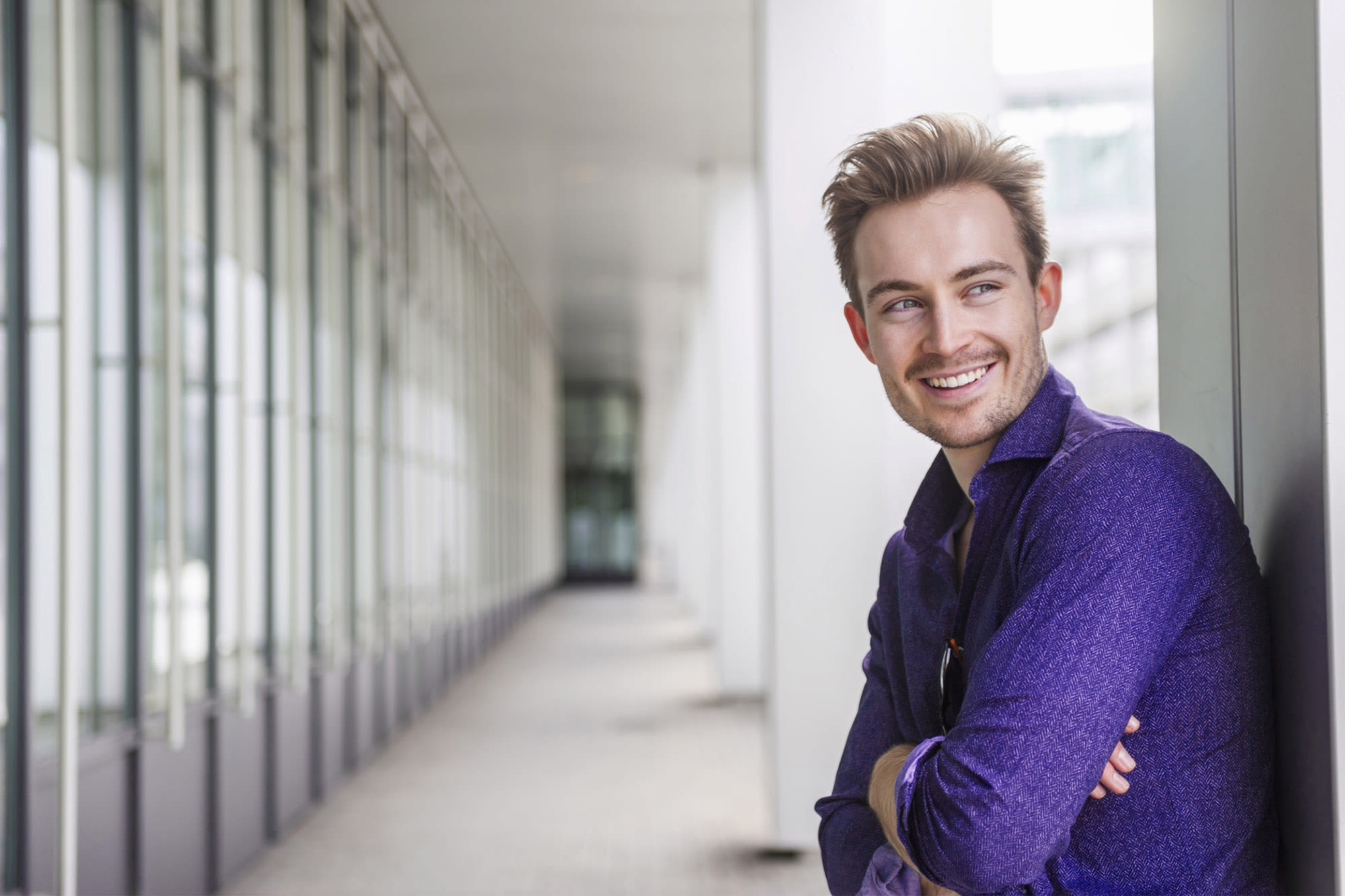 Mann in violettem Hemd lächelt im Business-Umfeld – individuelle Firmenkundenlösungen der BKS Bank. Mann in violettem Hemd lächelt im Business-Umfeld – individuelle Firmenkundenlösungen der BKS Bank.