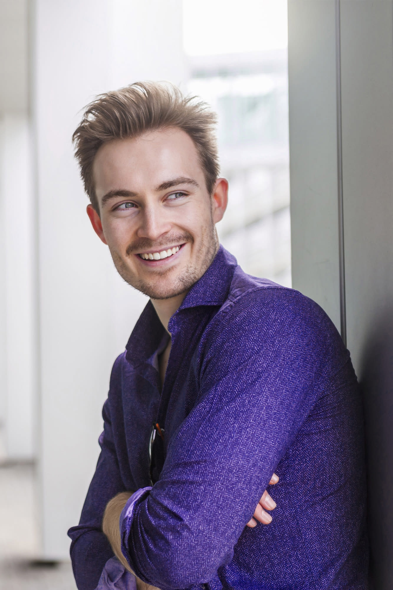 Mann in violettem Hemd lächelt im Business-Umfeld – individuelle Firmenkundenlösungen der BKS Bank. Mann in violettem Hemd lächelt im Business-Umfeld – individuelle Firmenkundenlösungen der BKS Bank.