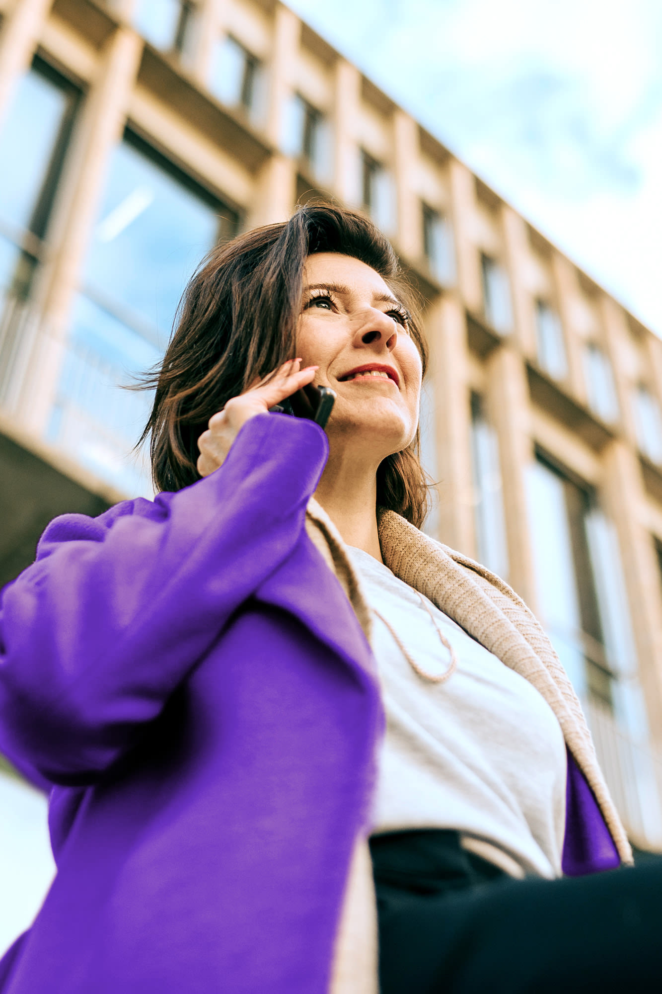 Frau telefoniert vor Bürogebäude – Komfort-Konto für moderne Geschäftskunden. Frau telefoniert vor Bürogebäude – Komfort-Konto für moderne Geschäftskunden.