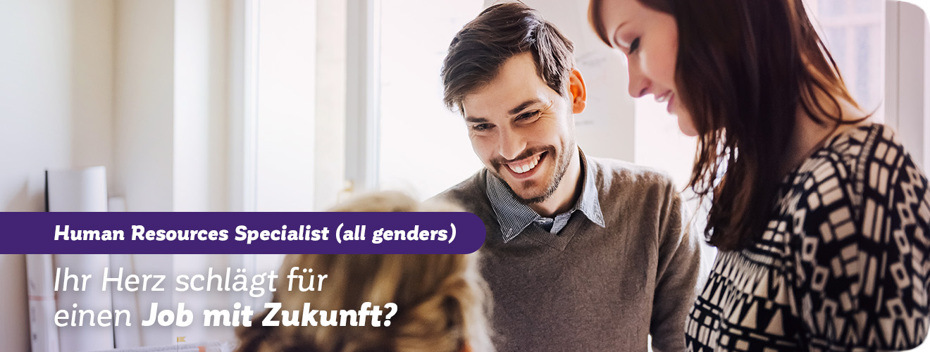 Junge Mitarbeiter lächeln sich an. Slogan: „Ihr Herz schlägt für einen Job mit Zukunft?“