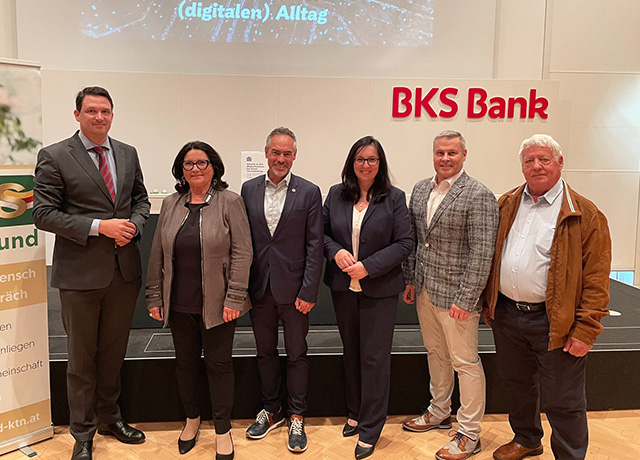 Sechs Personen stehen vor der Kamera. Dahinter ist das BKS Bank Logo zu sehen.